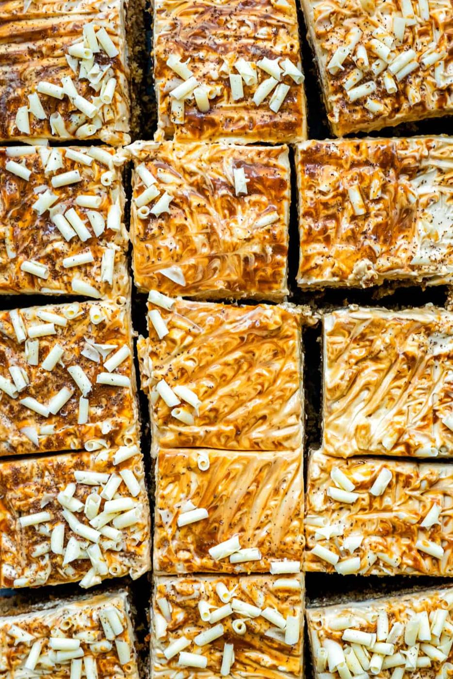 Overhead view of sliced banana tray bake cake with cream cheese frosting and caramel