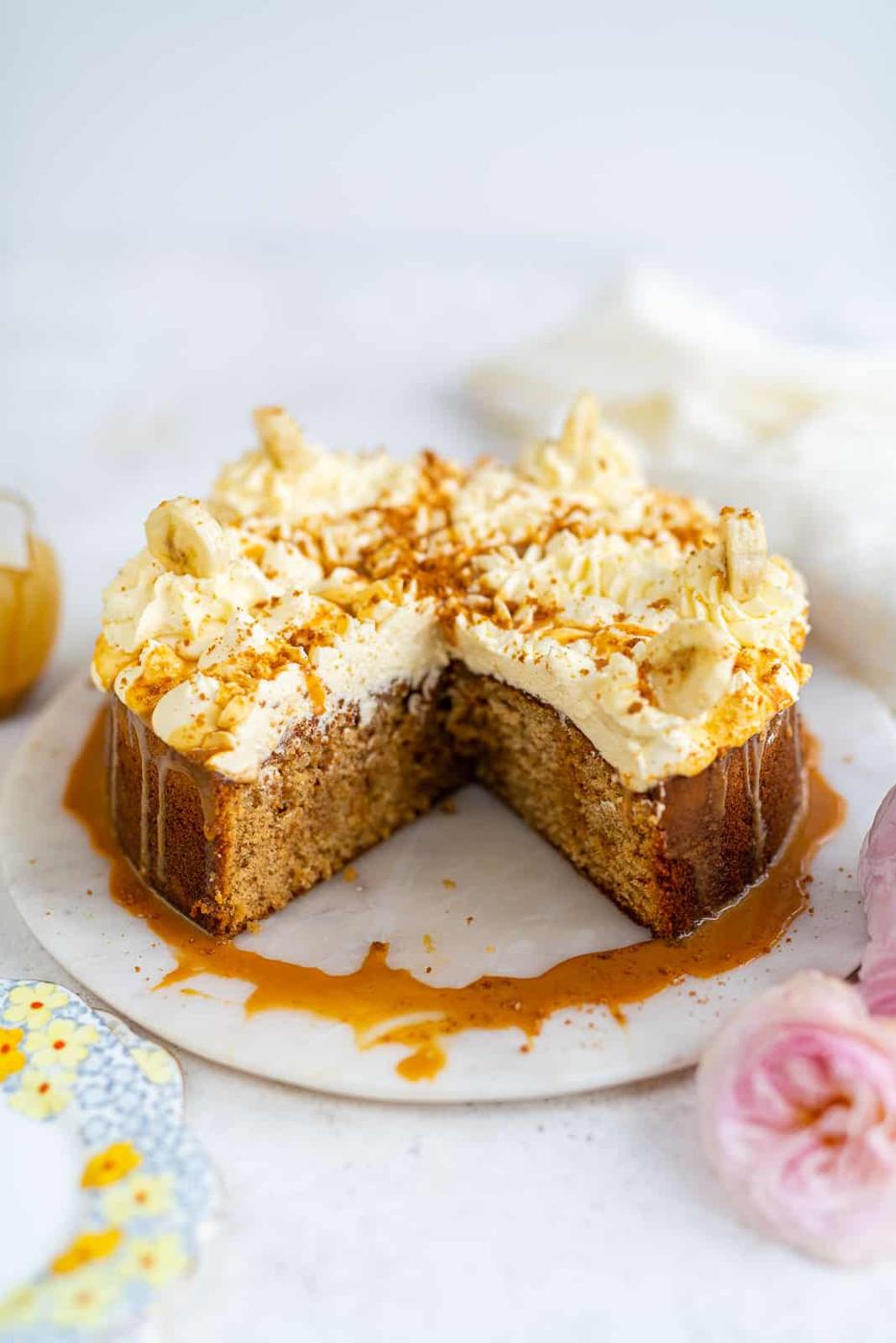 Banoffee cake with slice taken out on a marble plate