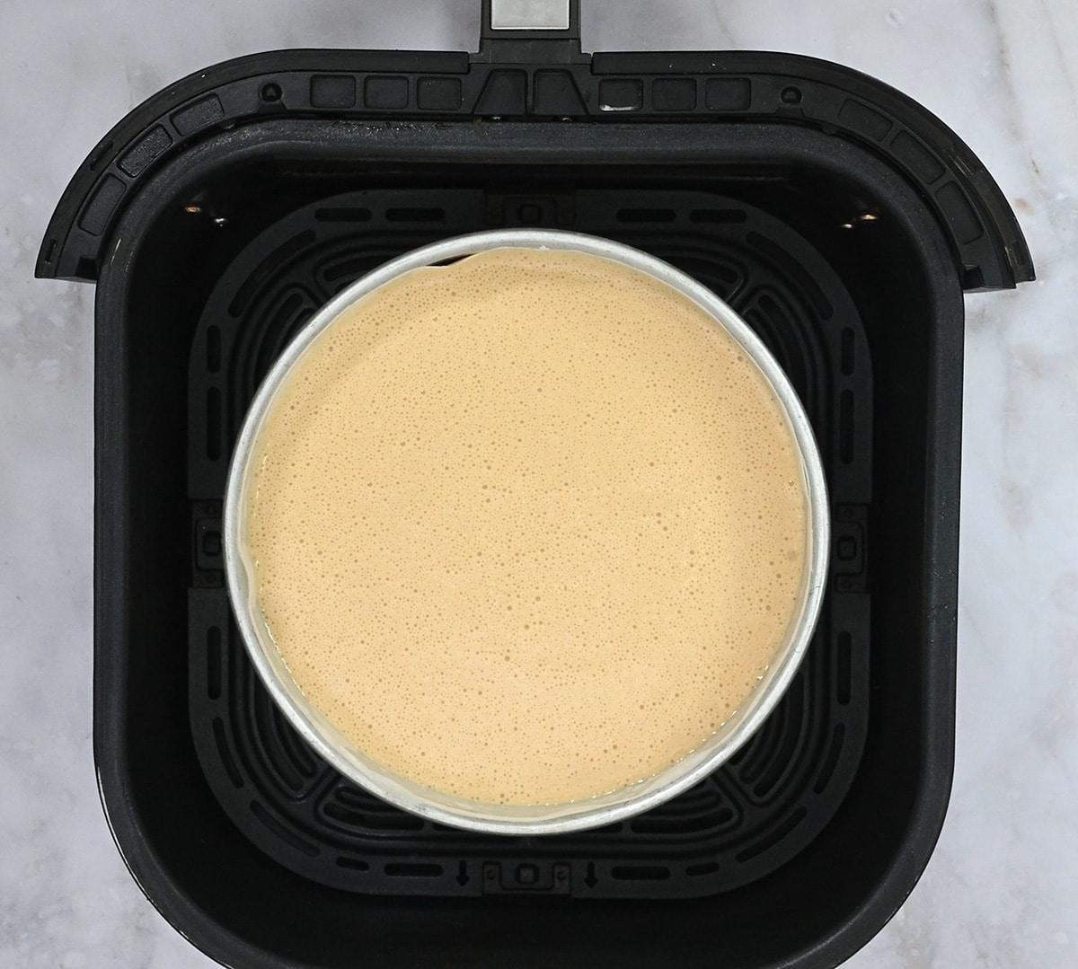 Banoffee cheesecake in an air fryer basket prior to baking