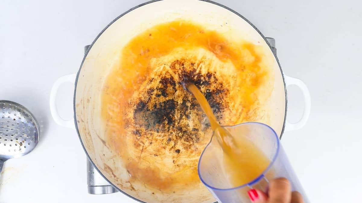 Deglazing a casserole dish with beef stock