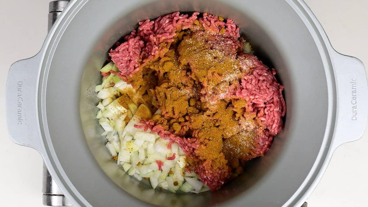 Onions, beef mince, curry powder and salt in a slow cooker