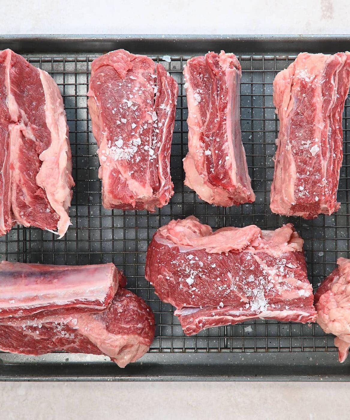 beef short ribs on a wire rack seasoned with coarse