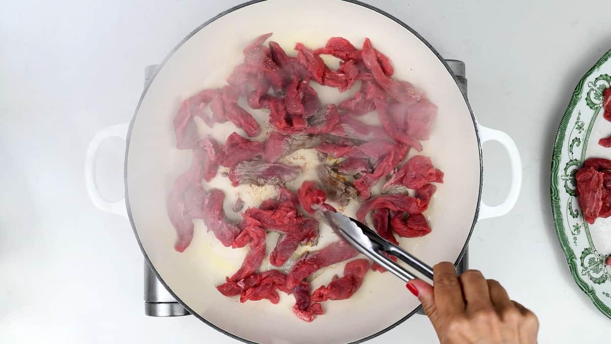 Browning strips of beef in a casserole