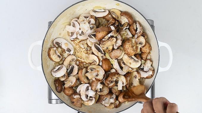 pan frying mushrooms and onions in a shallow casserole