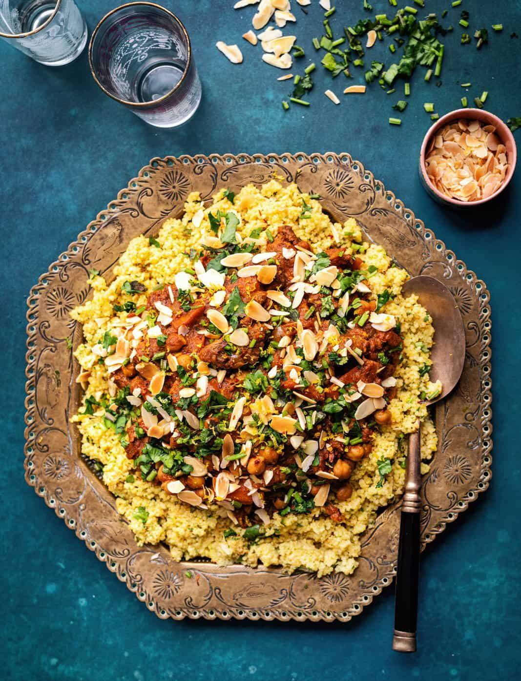 Moroccan Beef Tagine cooked in the slow cooker served over couscous on an ethnic platter