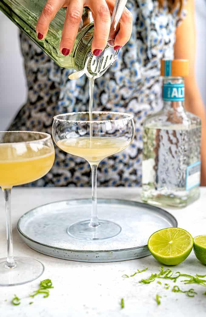 Straining a Cadillac Margarita into a coupe glass frosted with salt