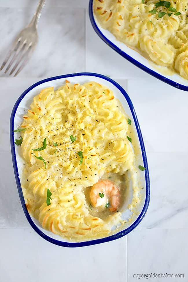 Mini fish pie with swirled mashed potato topping in a blue-rimmed enamel pie dish
