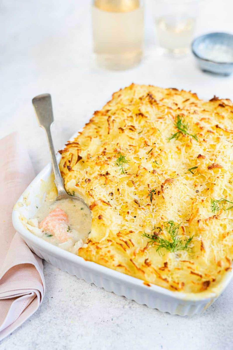 Classic fish pie with cod, salmon and smoked haddock in a rich white sauce, topped with golden mashed potatoes, with a spoonful removed