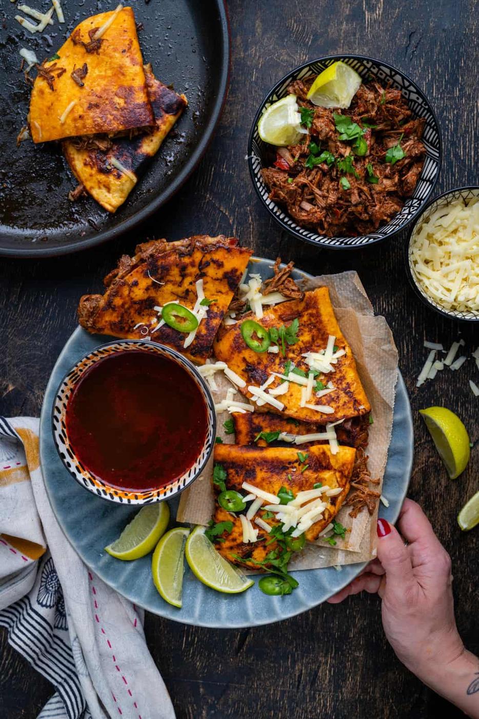 Overhead view of plate with birria tacos and dipping sauce