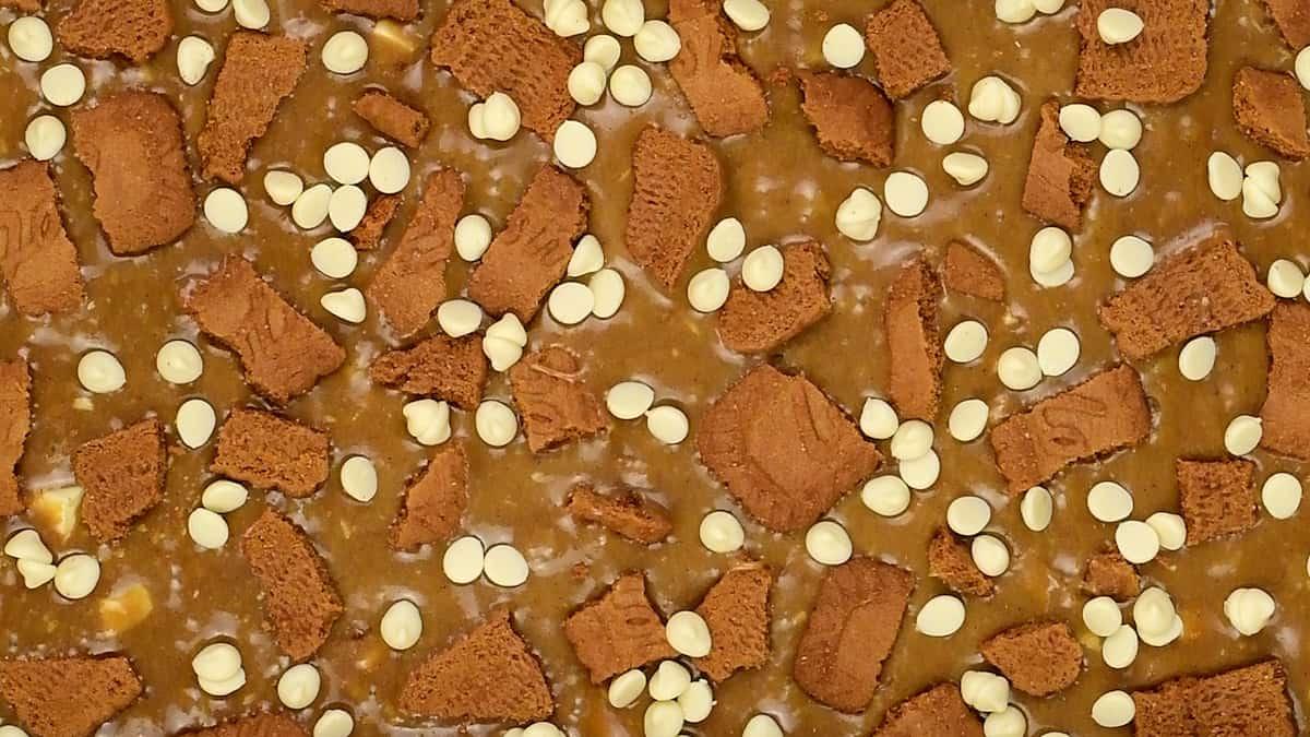 blondie batter topped with Biscoff biscuits and white chocolate chips