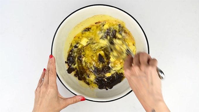 stirring chocolate and melted butter together in a bowl