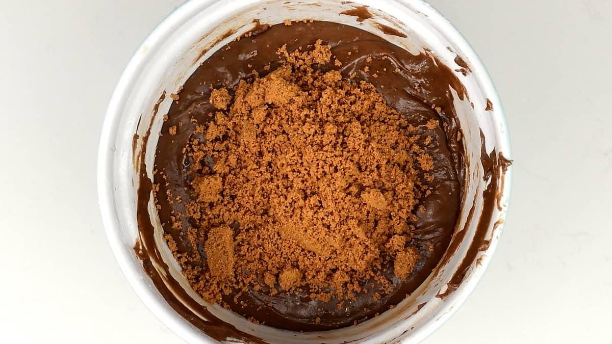 Biscoff biscuit crumbs in bowl of fudge mixture