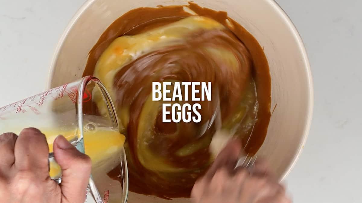 Mixing eggs into Biscoff muffin batter