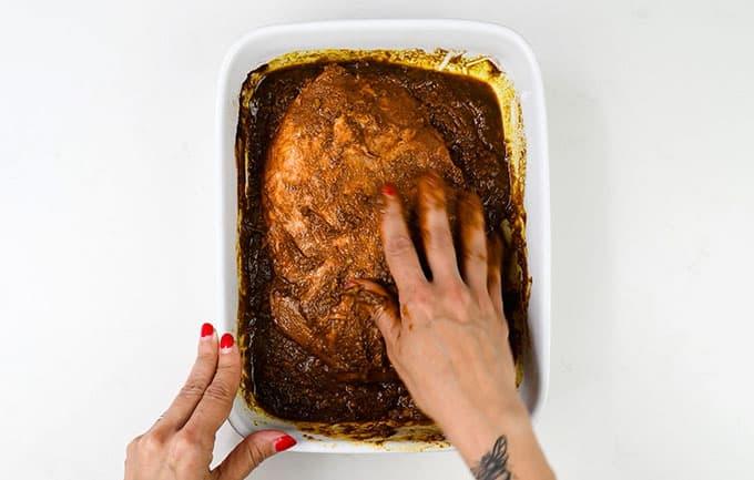 Rubbing boneless leg of lamb with BBQ marinade