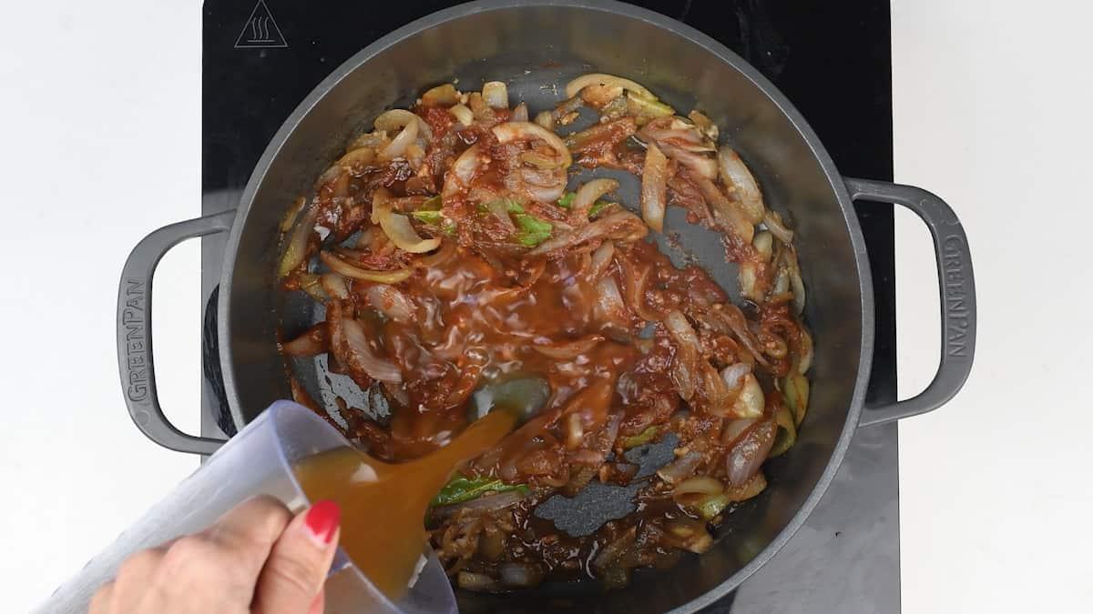 Adding red wine and stock to pot for braised beef