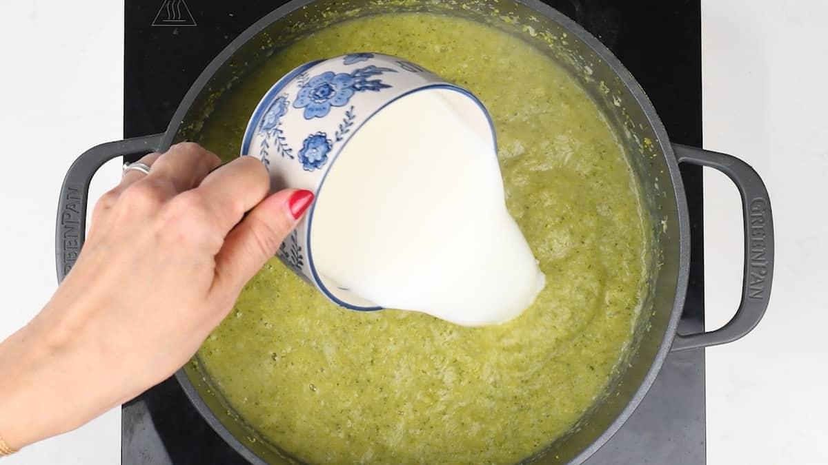 adding milk to broccoli soup