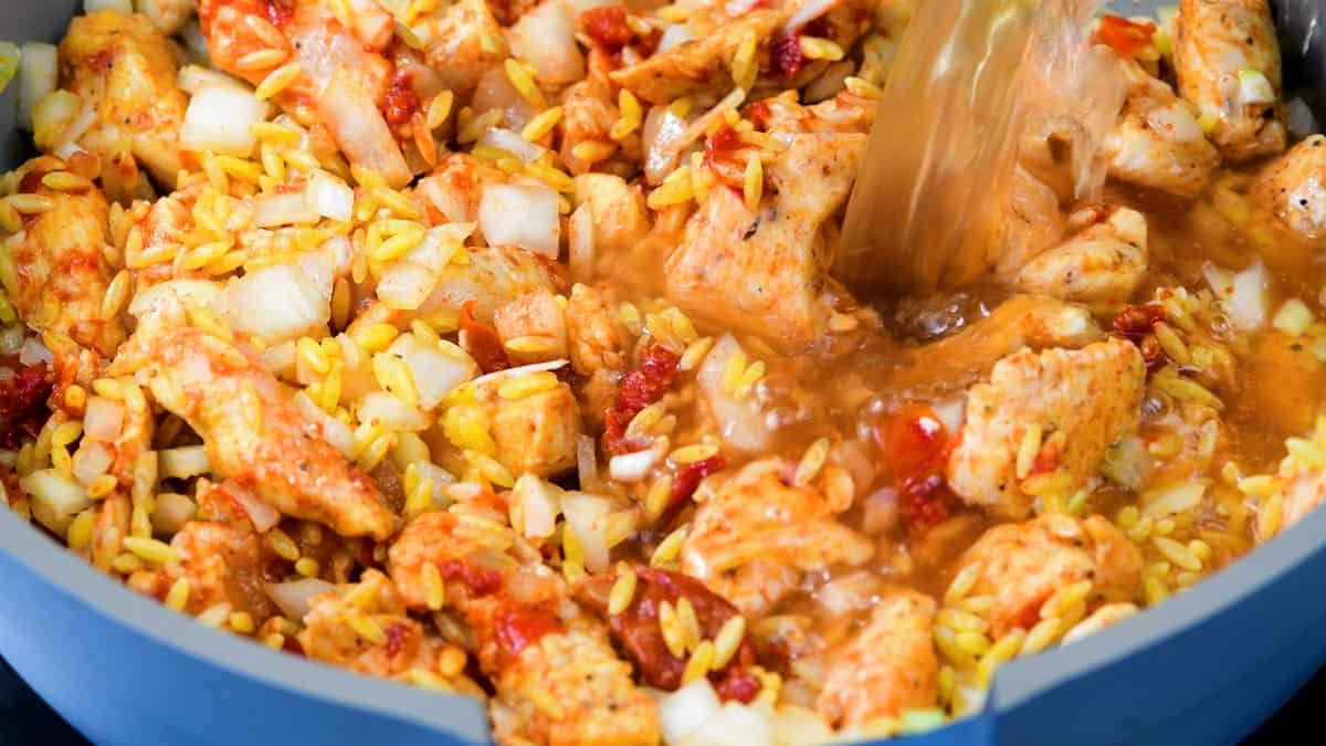 orzo cooking in a pan with chicken