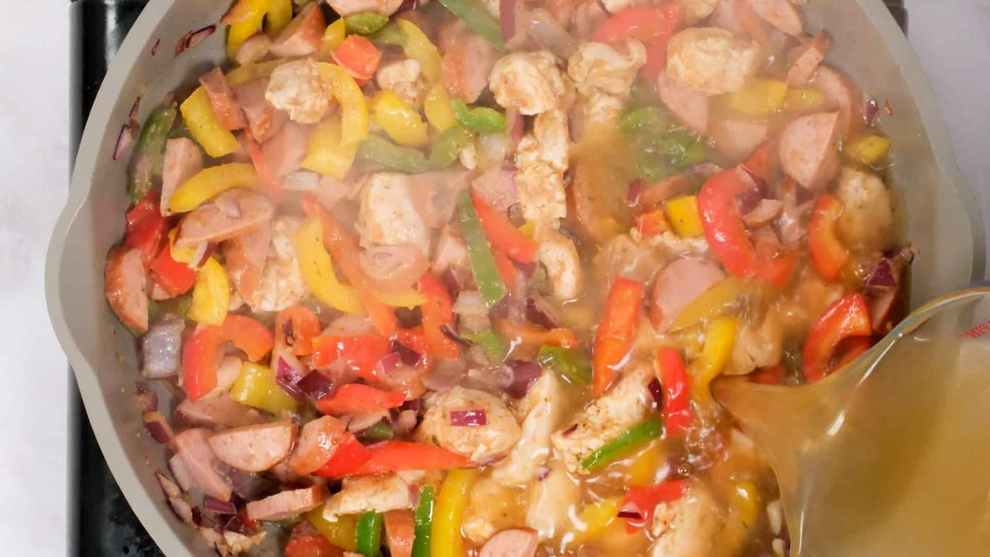 adding chicken stock to Jambalaya style pasta dish