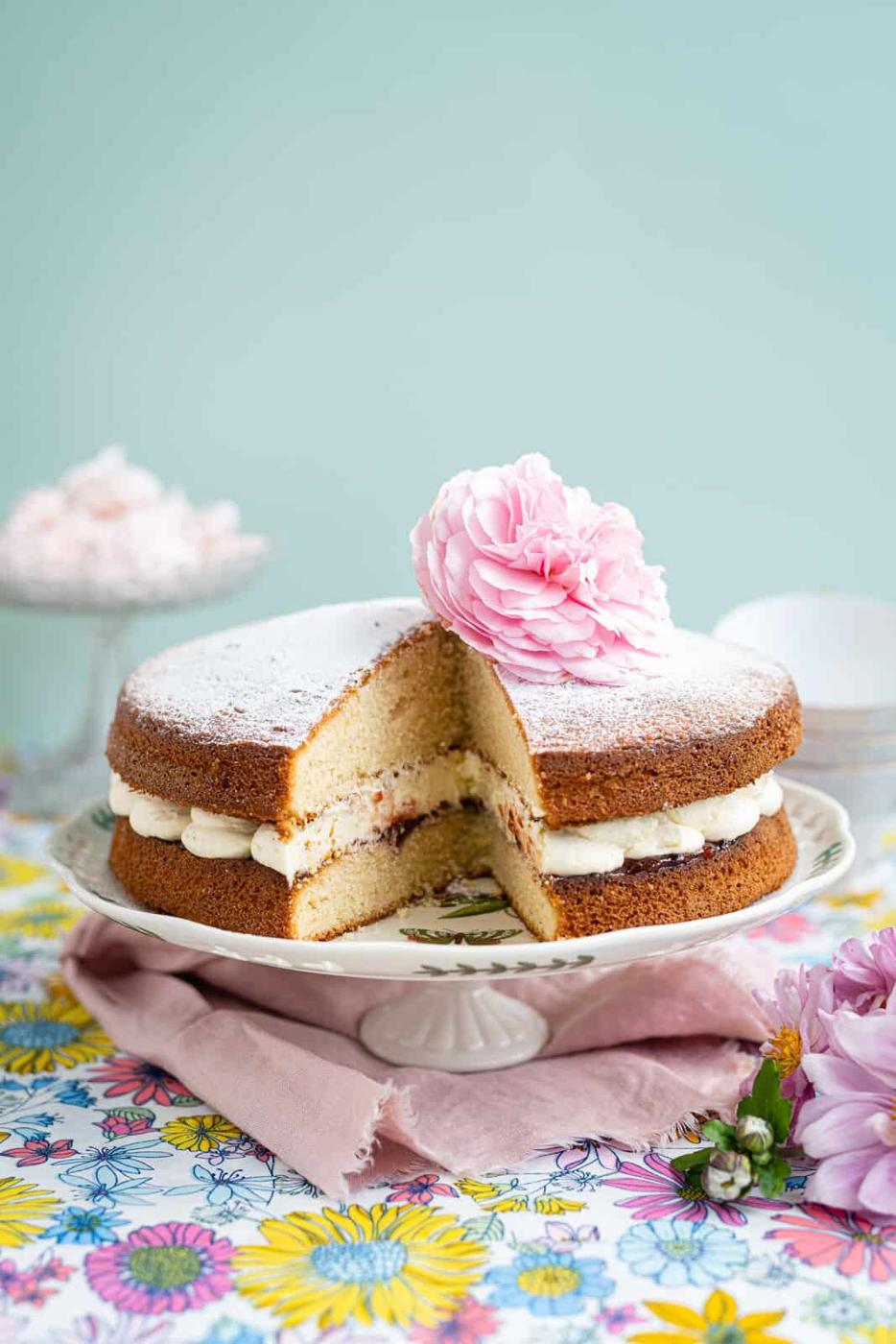 Victoria cake with slice taken out on a cake stand