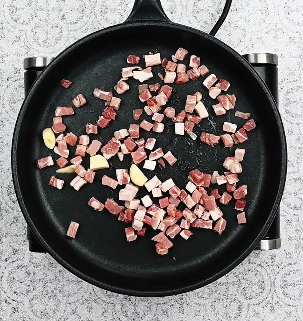 pan frying pancetta in a skillet