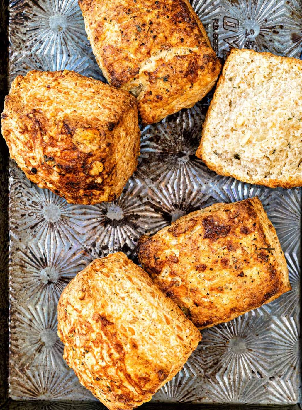 Close up on flaky cheese sourdough biscuits on a metal baking tray
