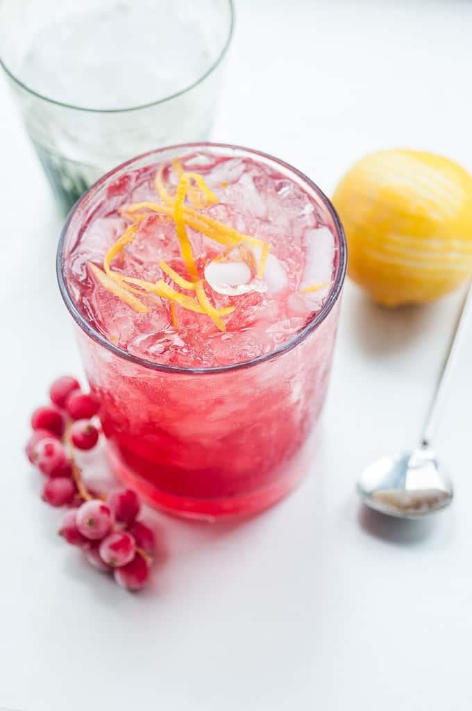 Summer Gin cocktail in a glass with crushed ice garnished with lemon strips
