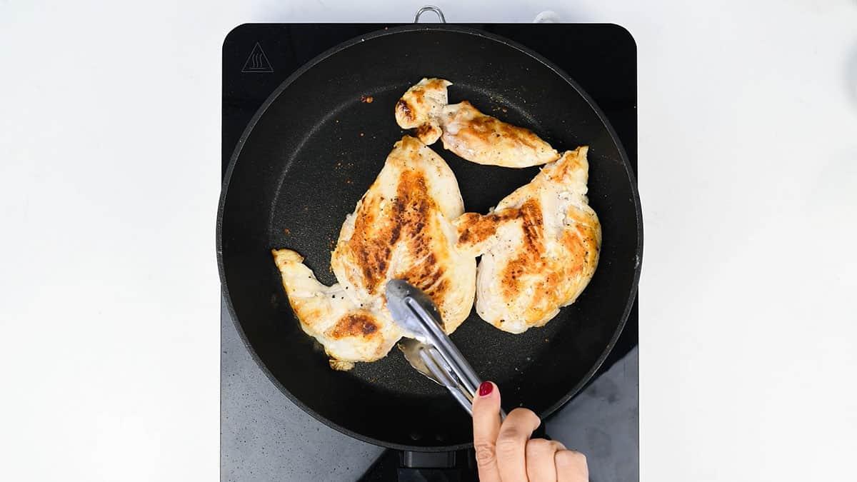 pan frying chicken breasts in a skillet