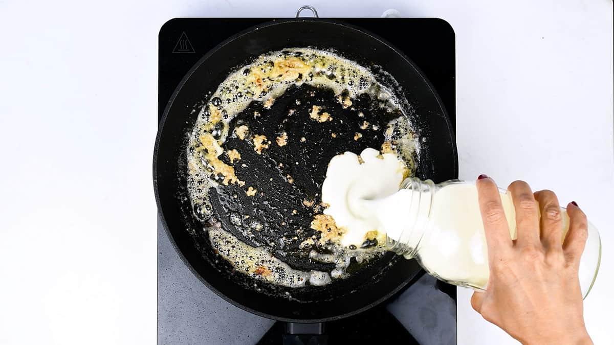 adding cream to a skillet