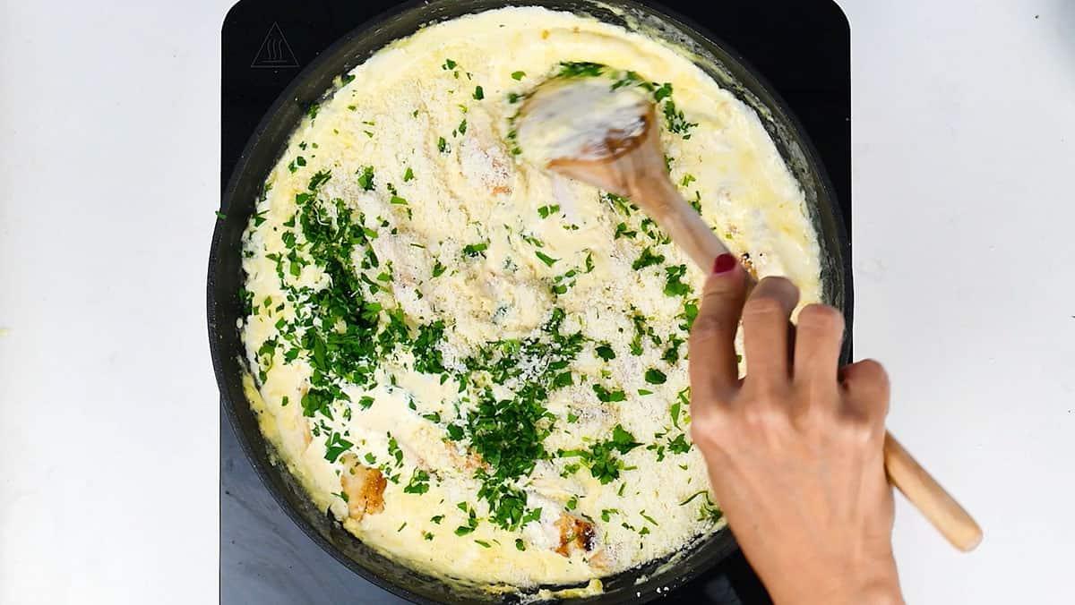 Preparing creamy Alfredo sauce in a skillet