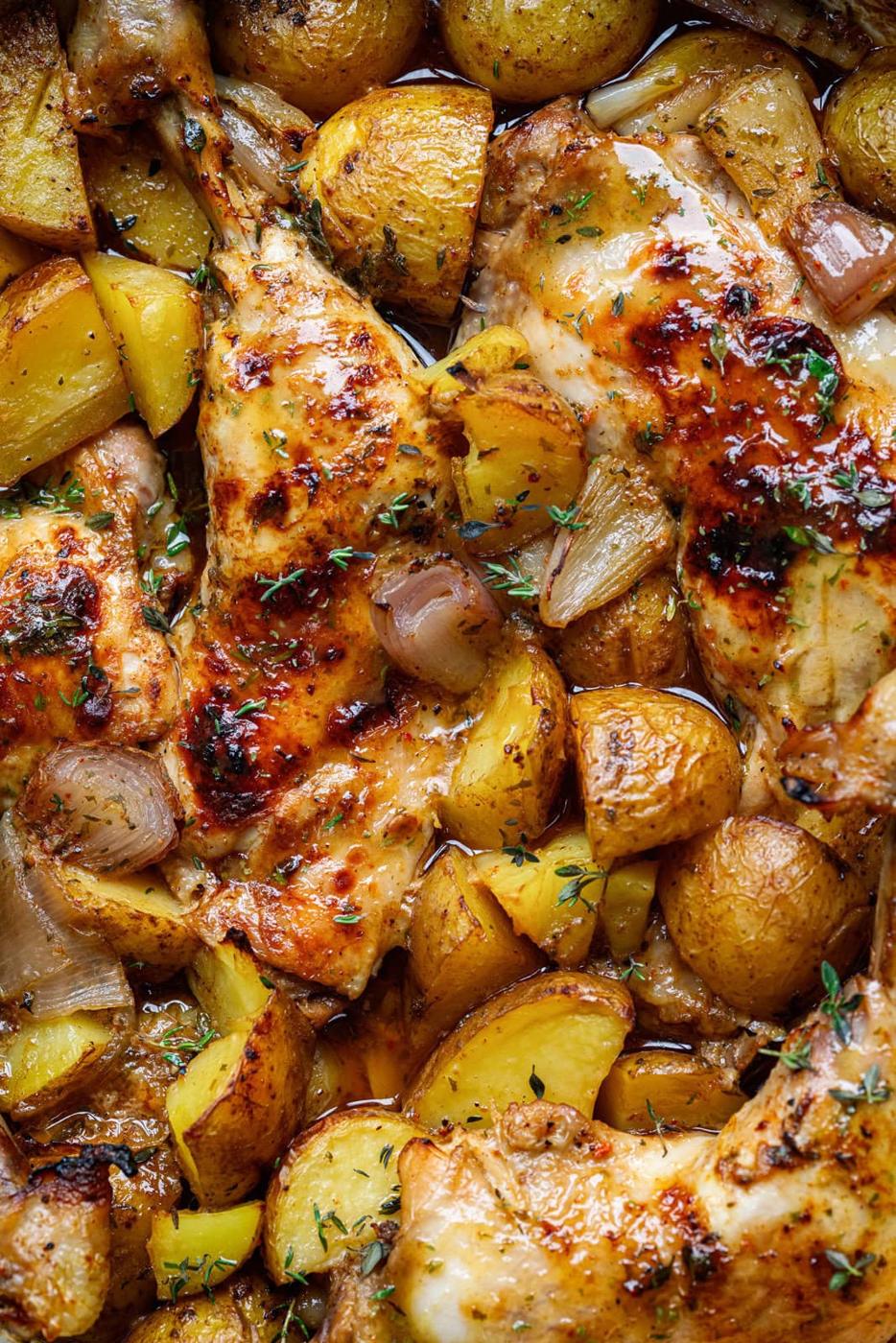 extreme close up on a pan of oven roasted chicken and potatoes