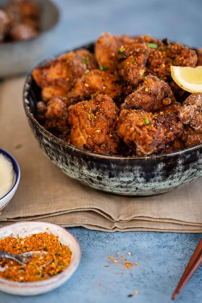 Bowl of crispy Chicken Karaage with Japanese Seven Spice seasoning and lemon wedges
