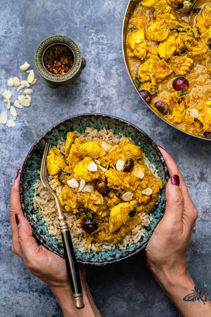 Chicken Korma served over brown rice in a bowl