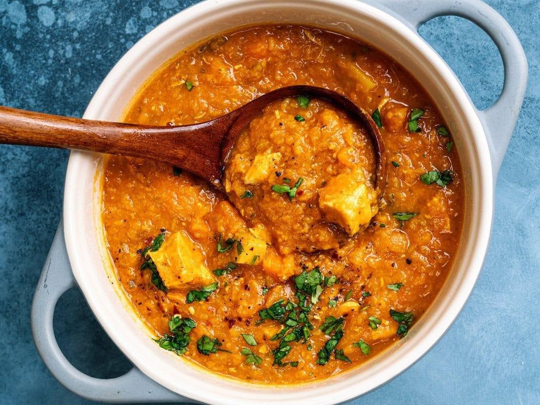 Pot of chicken and lentil soup with a ladle