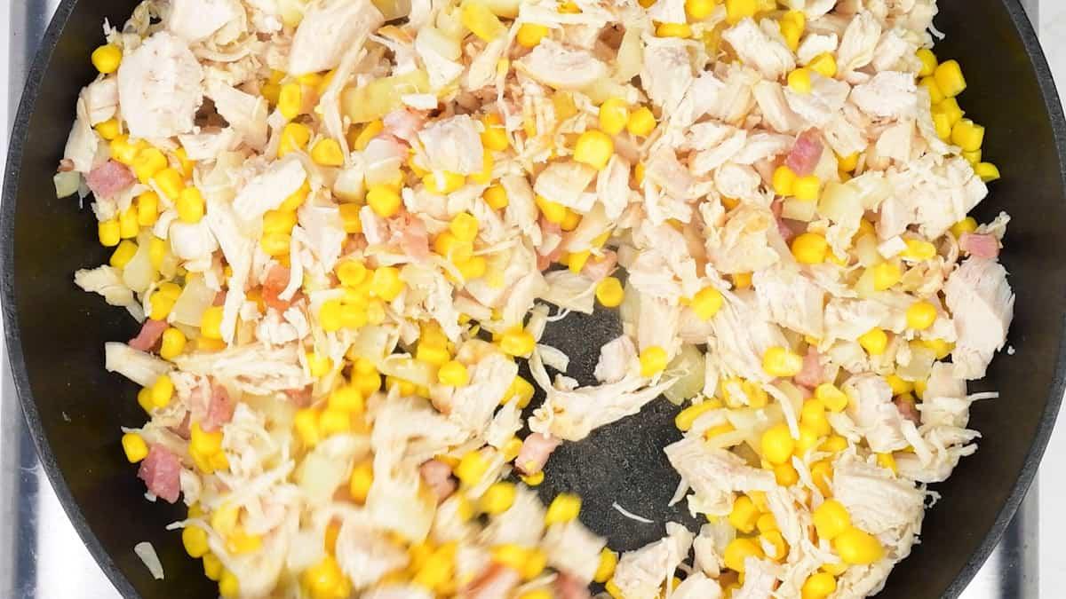 diced chicken, corn, bacon and onions in a pan