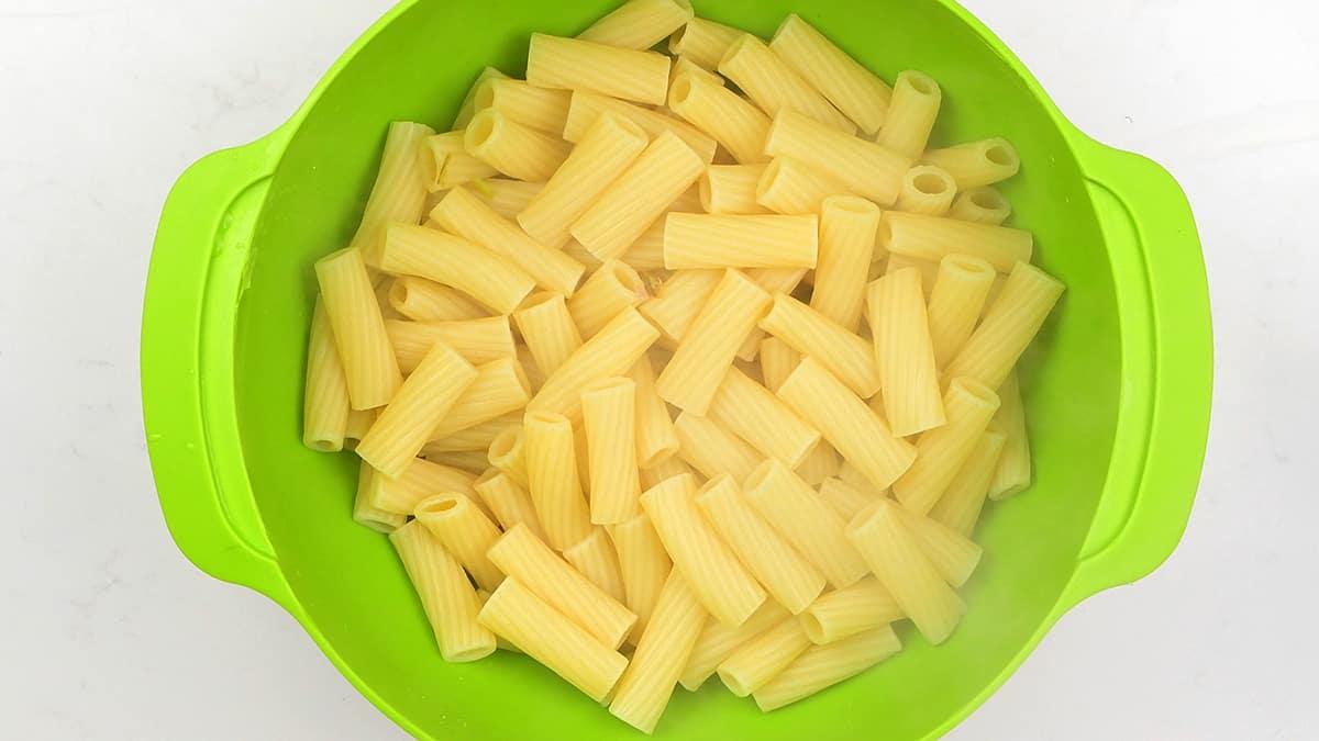 cooked rigatoni pasta in a green colander