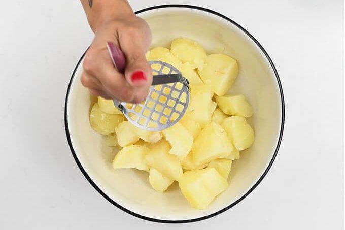 mashing boiled potatoes