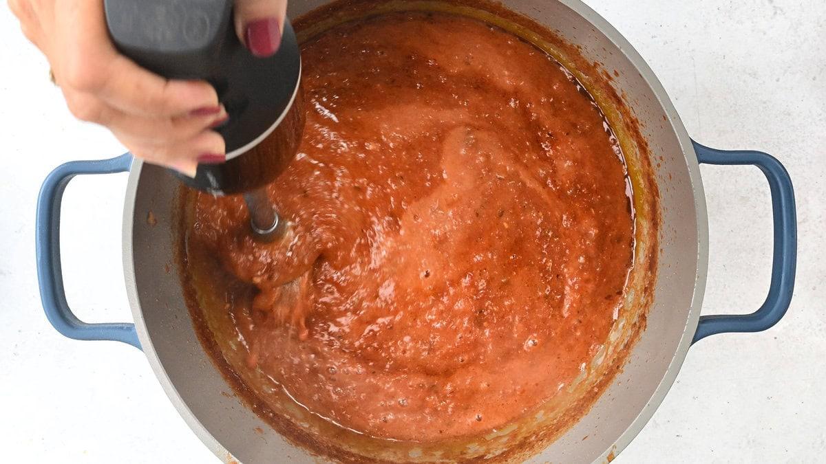 Blending Tinga sauce with an immersion blender