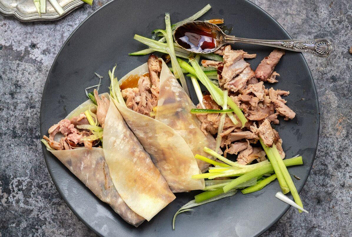 Chinese aromatic crispy duck served in pancakes with Hoisin sauce, cucumber and spring onions