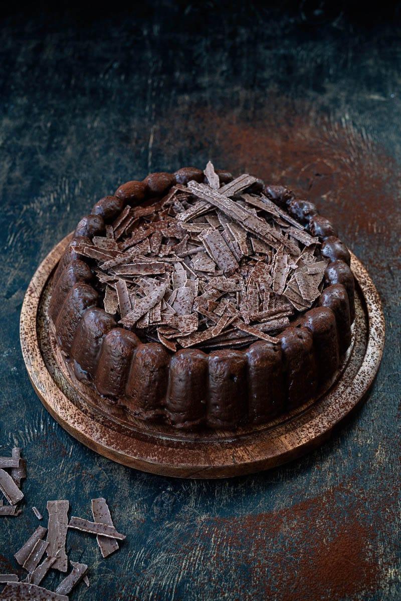 chocolate almond cake covered with chocolate shards against a dark background