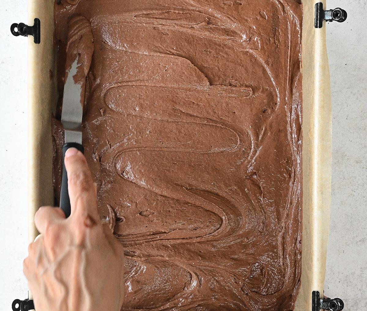 spreading cake batter in a rectangular sheet cake pan