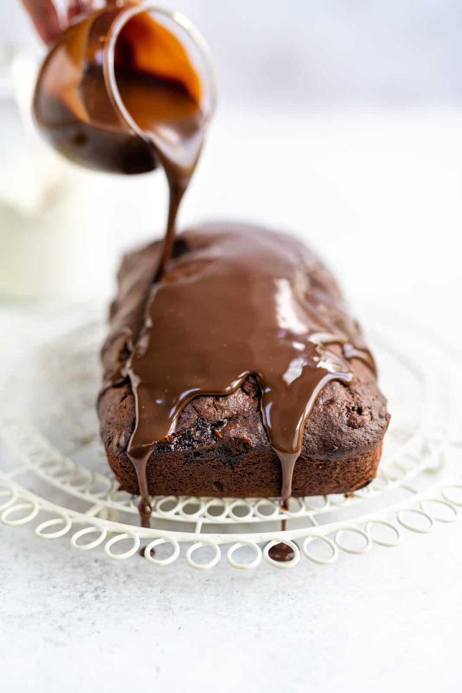Drizzling chocolate sauce over chocolate banana cake