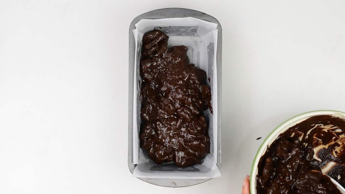 packing chocolate biscuit cake mixture into a small lined loaf tin