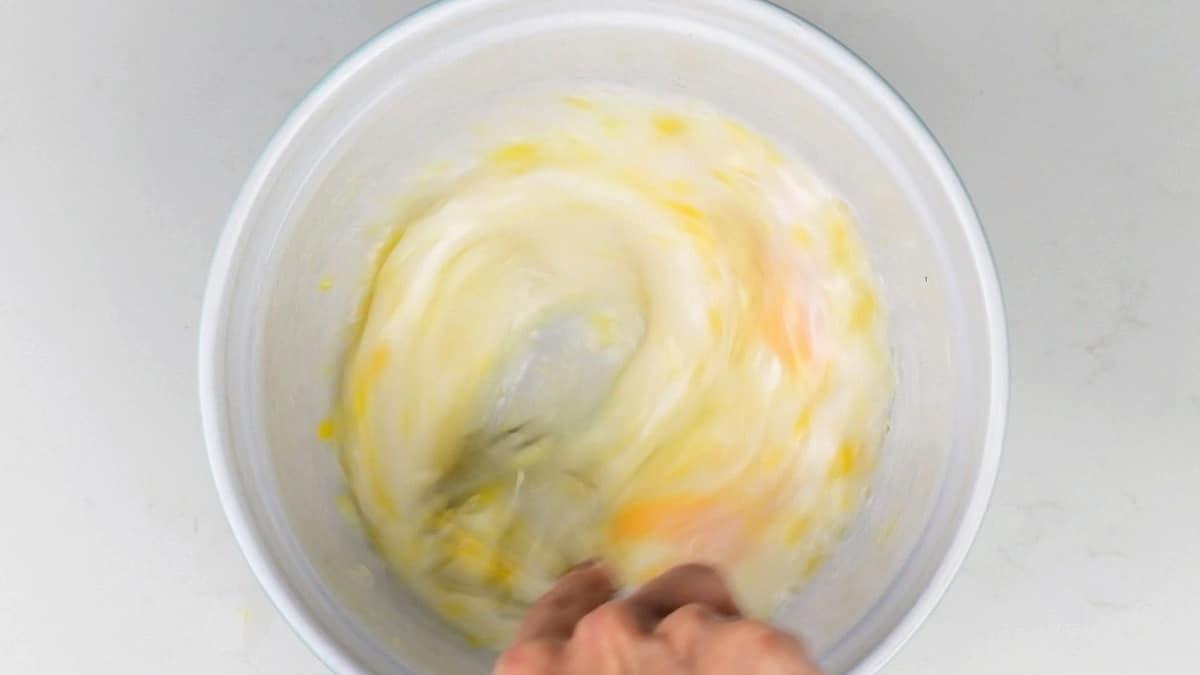 mixing eggs, milk and butter in a bowl