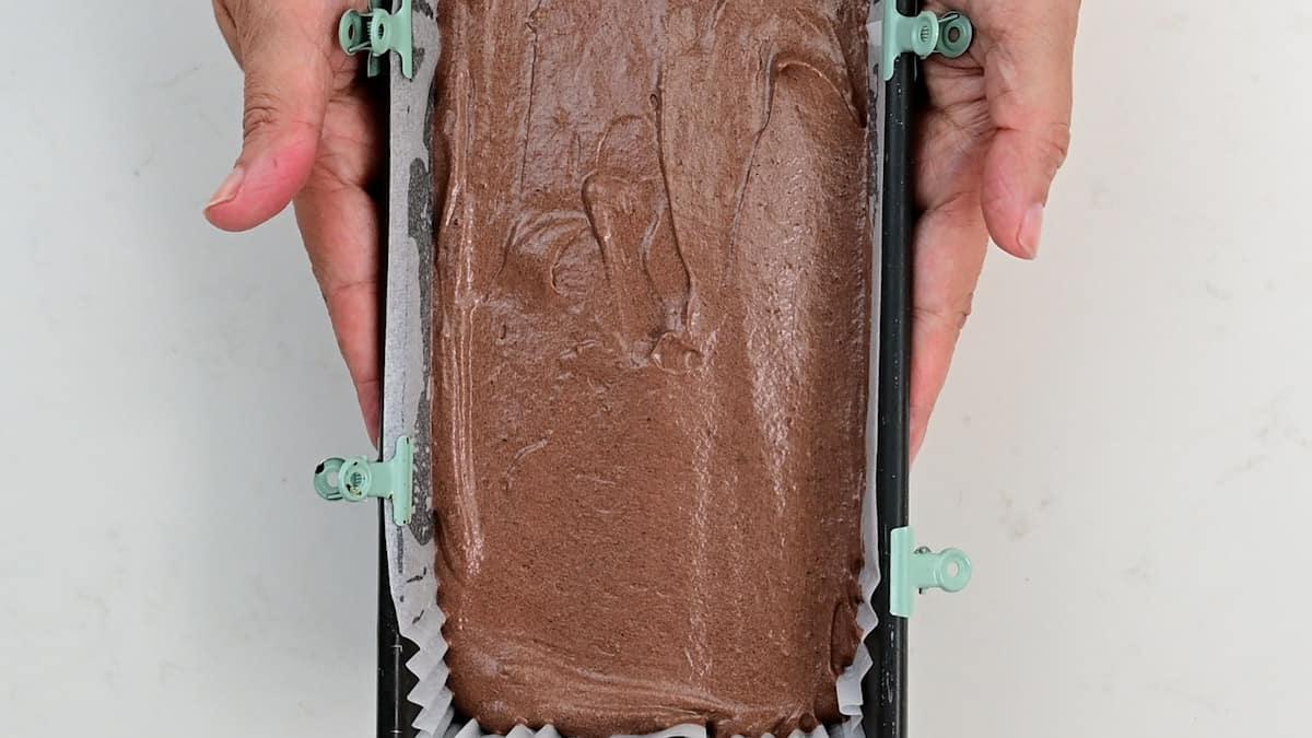 Chocolate cake batter in a lined loaf tin