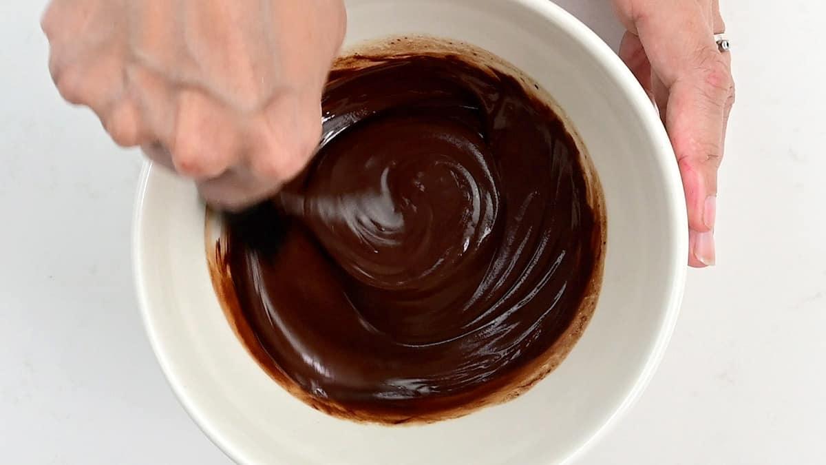 Stirring chocolate glaze in a bowl