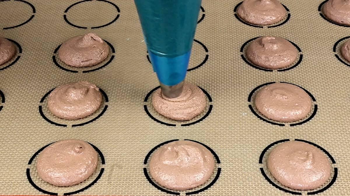 piping chocolate macarons