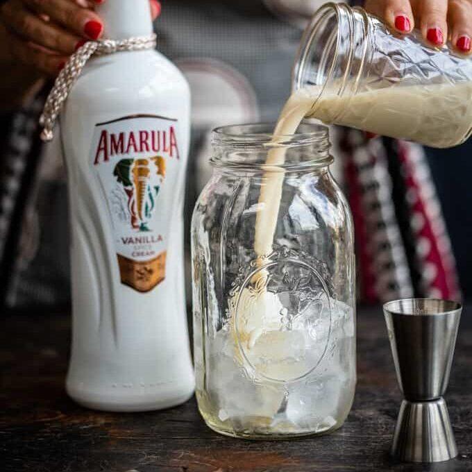 Pouring Amarula into cocktail shaker filled with ice