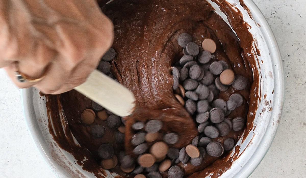 folding chocolate chips into muffin batter