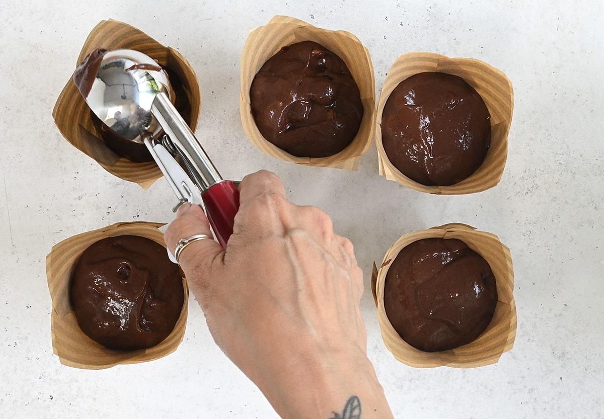 adding batter to tulip muffin cases