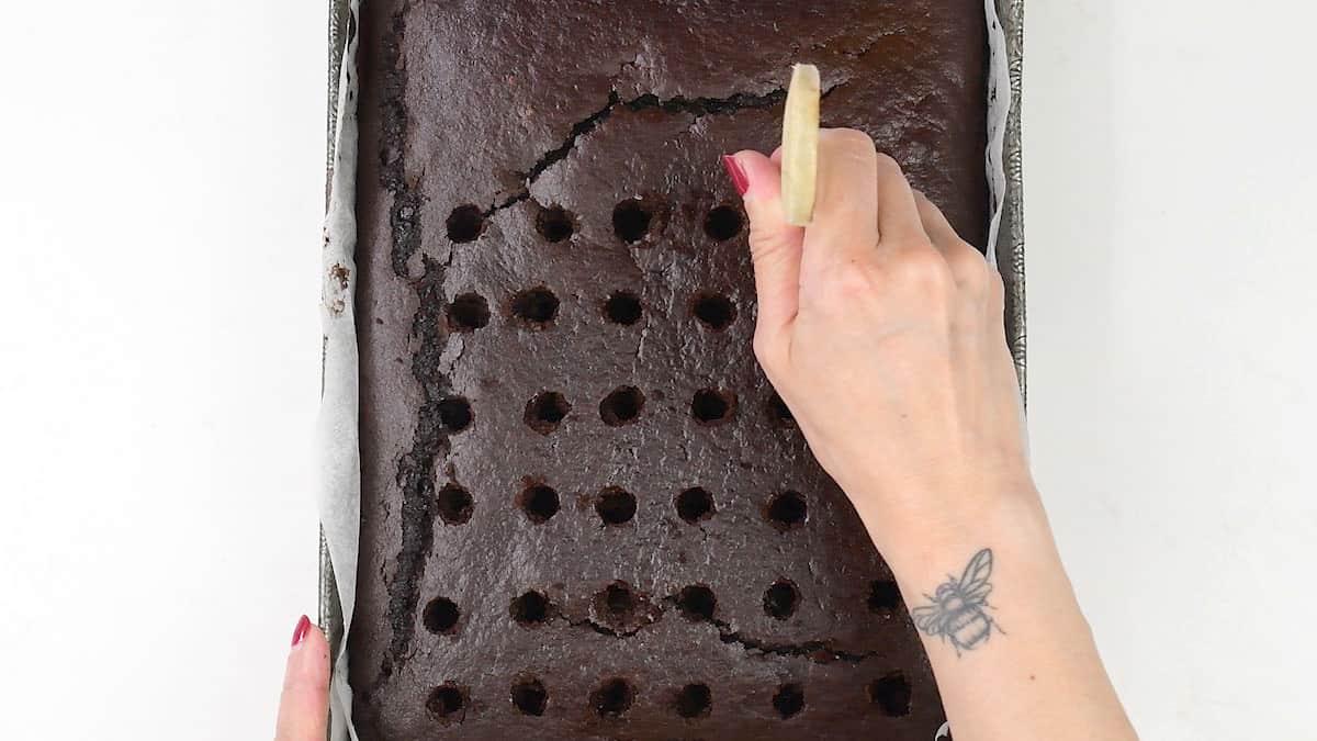 Poking holes on a chocolate sheet cake